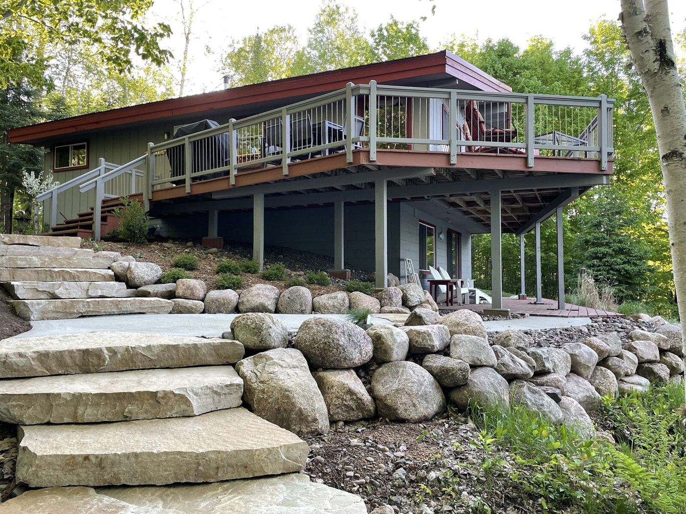 Two-story home with wrap-around deck and stone steps