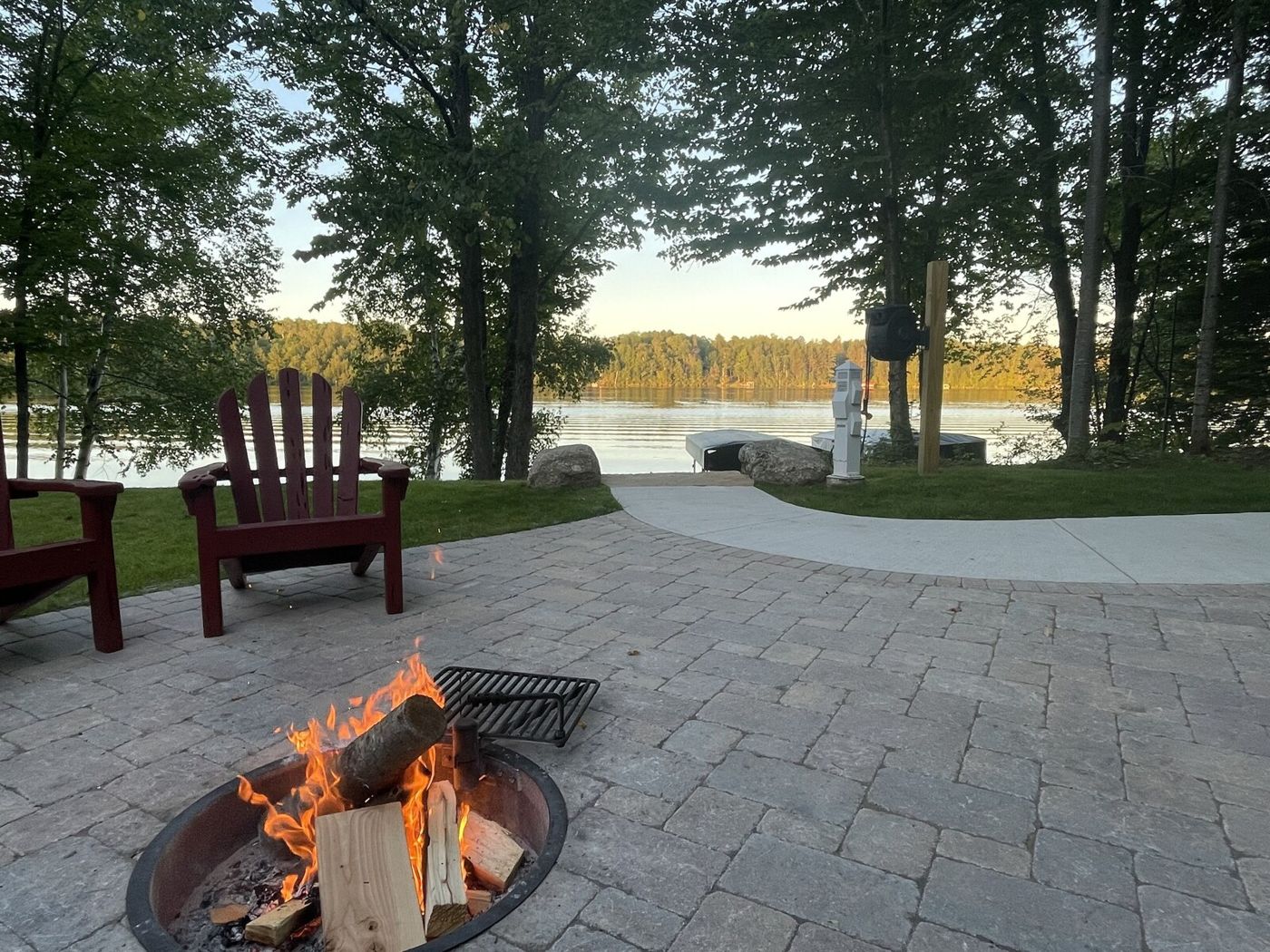 Fire pit with a red Adirondack chair overlooking the lake