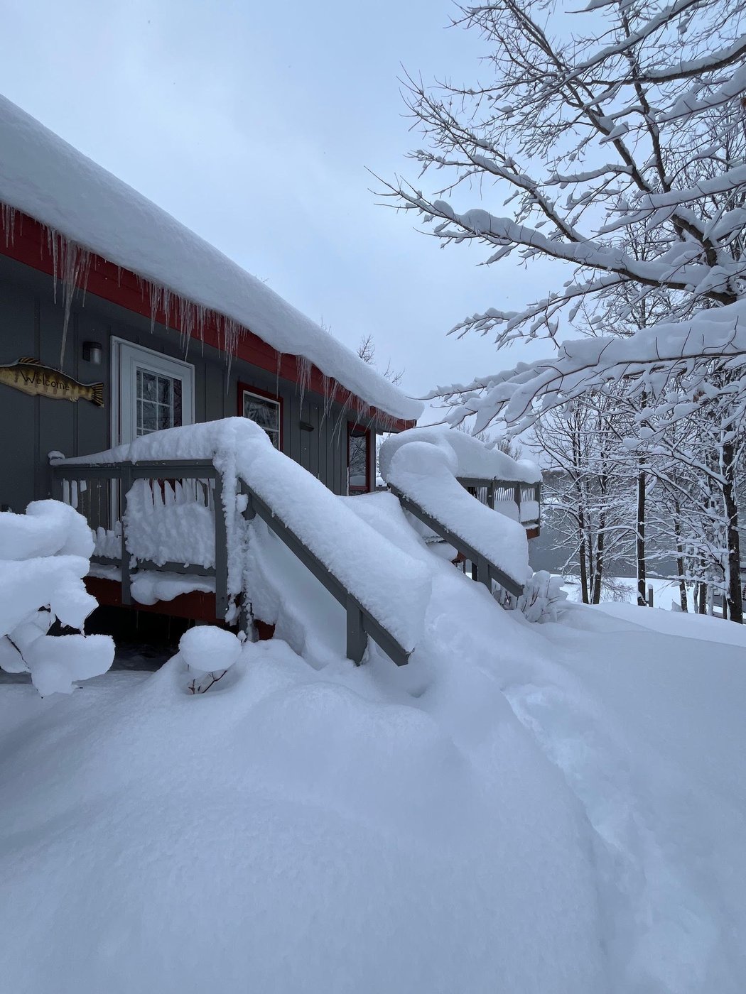 Snow-covered deck and stairs with icicles